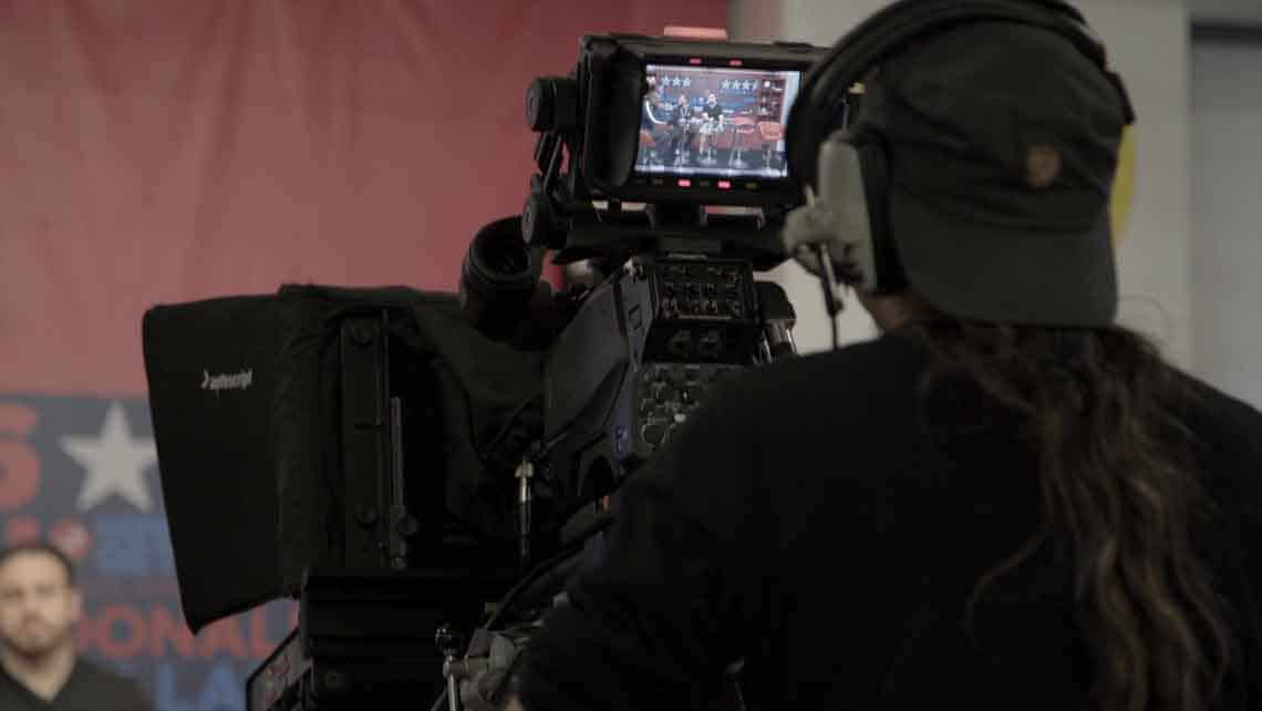Multiple cinematic 4K cameras facing a stage for a corporate hybrid event streaming production in Munich.