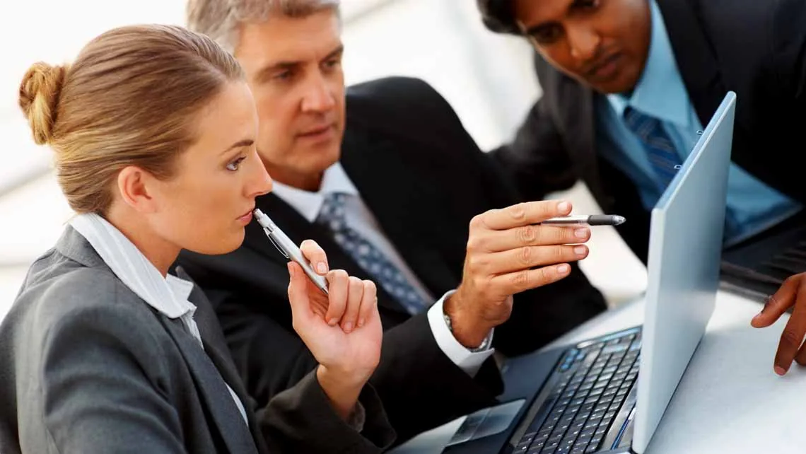 Business-Team bespricht Inhalte am Laptop während eines Events