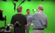Interview-Dreh im Greenscreen Studio München: Moderator vor grüner Hohlkehle mit Kamerateam, Boom-Mikrofonen und Fresnel-Scheinwerfern – LANIZMEDIA GmbH